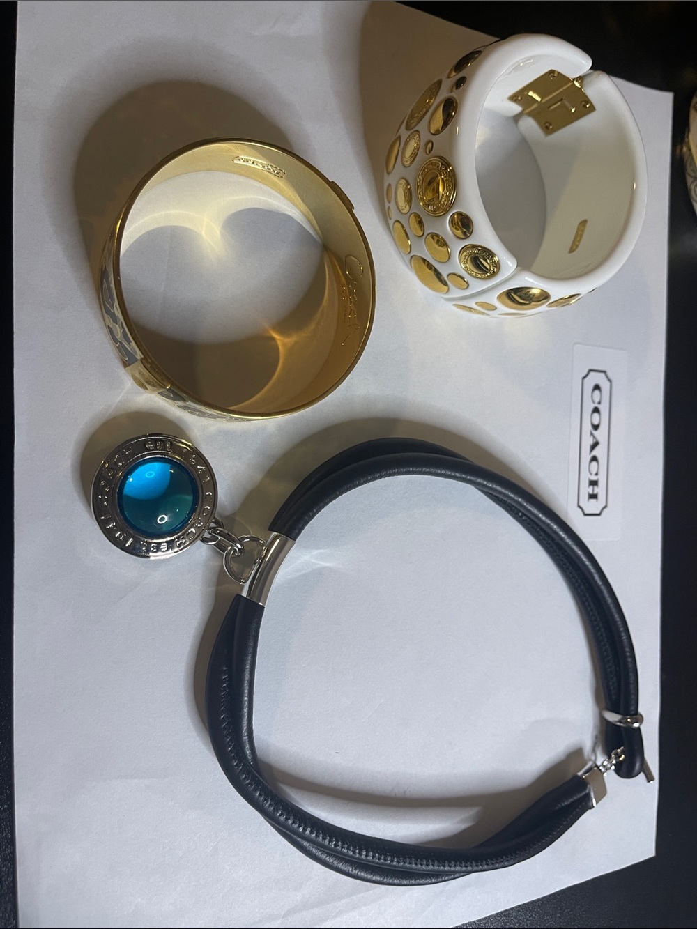 1 Coach Black Leather necklace with Blue Glass Charm and 2 Coach bracelets